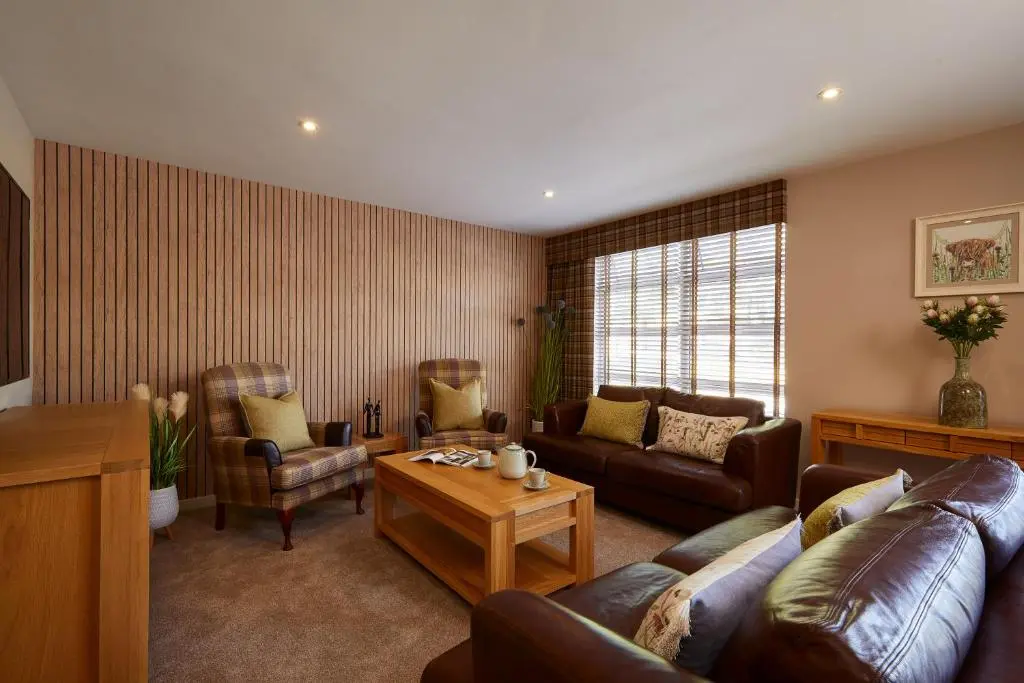 a living room with a couch and a table at Macdonald Woodland Lodges at Macdonald Aviemore Resort in Aviemore