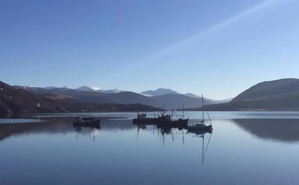 a couple of boats sitting in the water at Island View Guest House in Ullapool