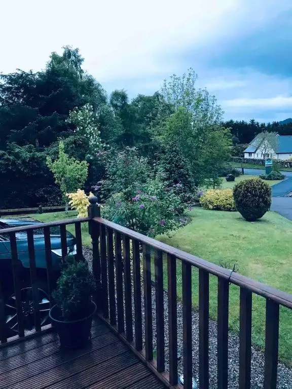 a wooden deck with a view of a yard at Carn A Chuilinn House in Fort Augustus