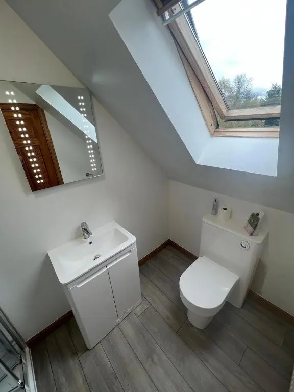 a bathroom with a toilet and a sink and a window at Carn A Chuilinn House in Fort Augustus