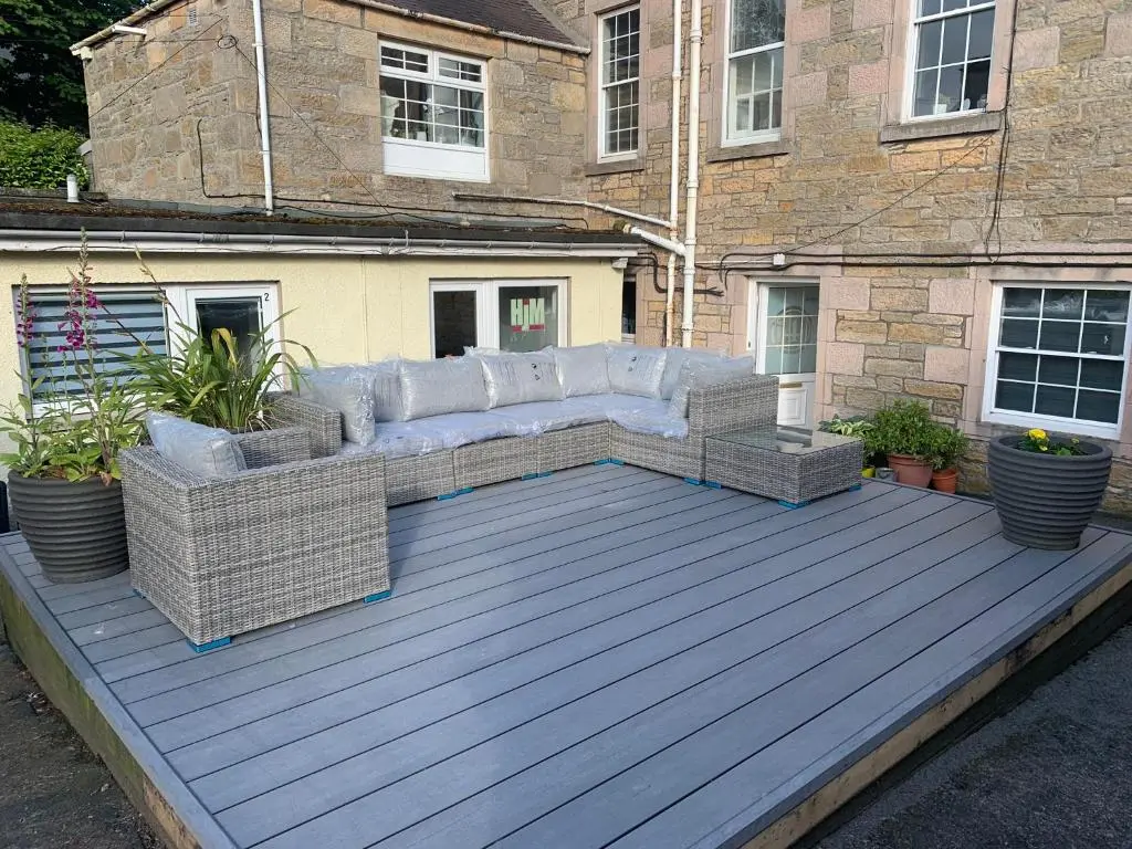 a patio with a couch on a wooden deck at Serviced Accommodation Moray in Elgin