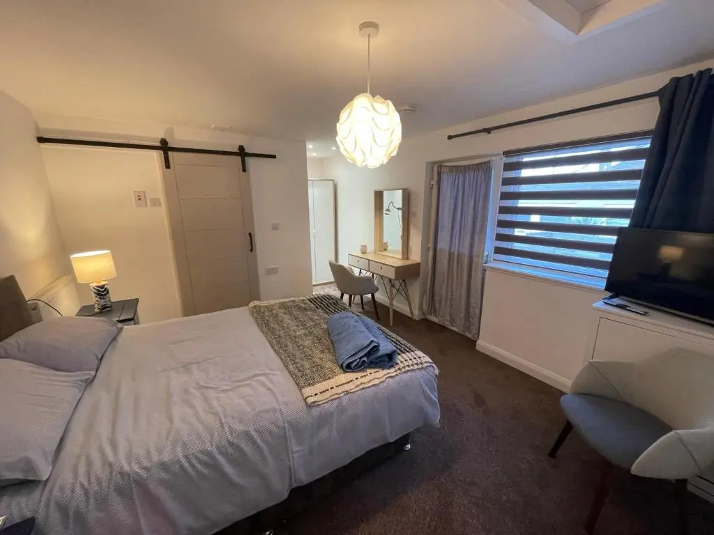a bedroom with a bed and a desk and a television at Serviced Accommodation Moray in Elgin