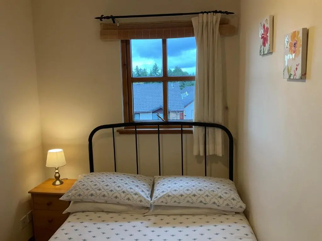a bedroom with a bed and a window at Culloden Apartment Free Parking in Inverness