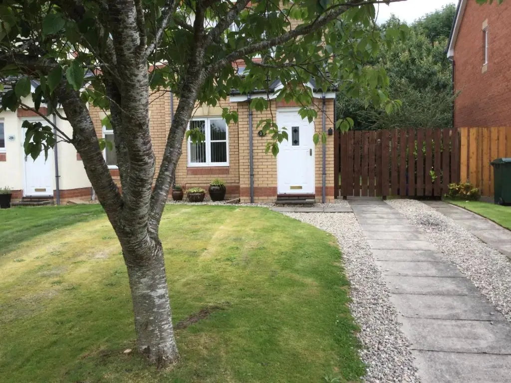 a house with a tree in the yard at Castle Heather House Free Parking in Inverness