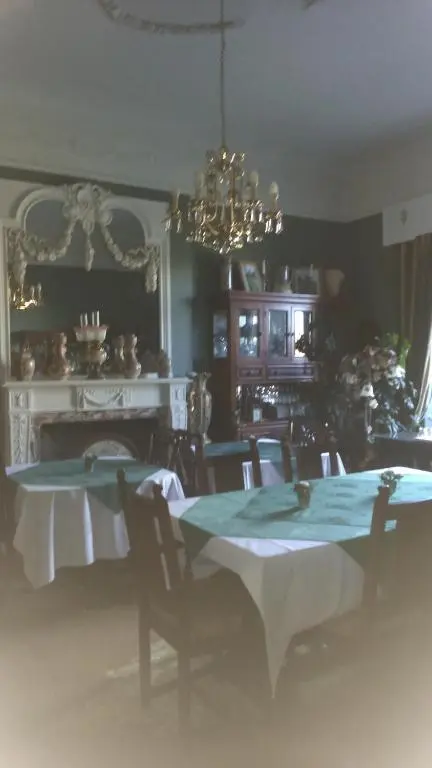 a dining room with a table and a chandelier at Disblair House in Newmachar