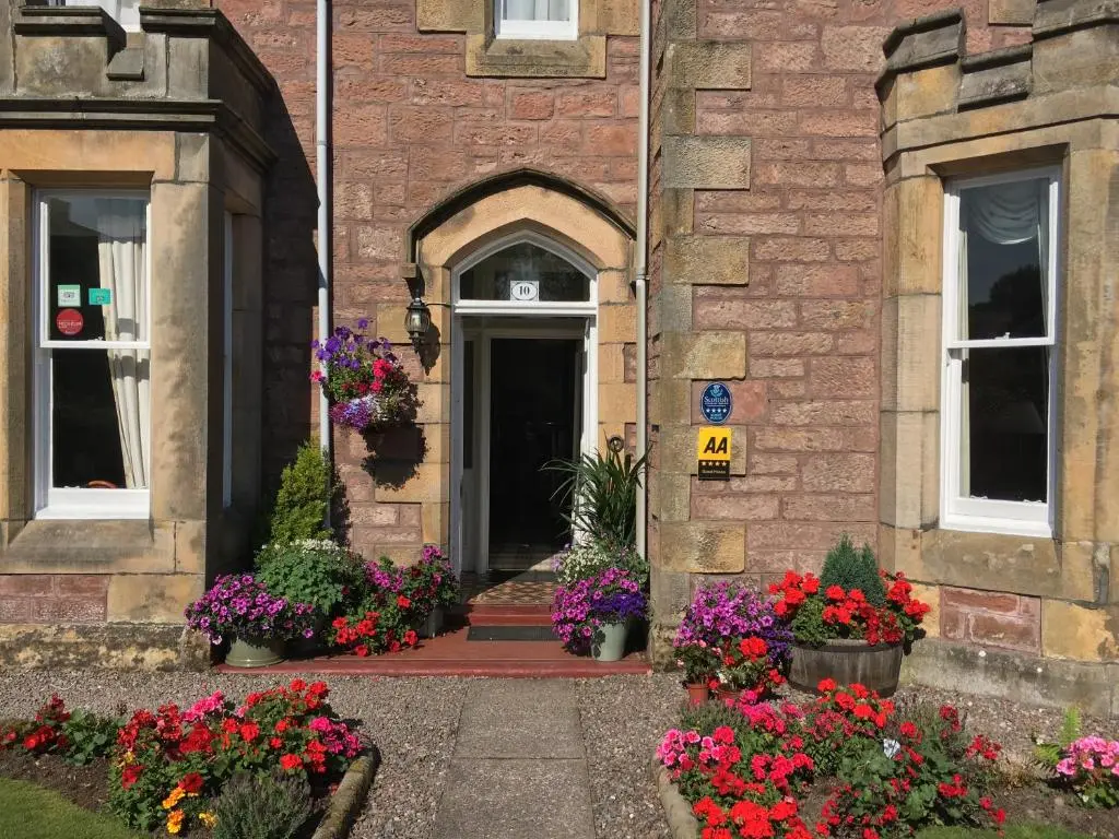 an entrance to a brick building with pots of flowers at Ballifeary House in Inverness