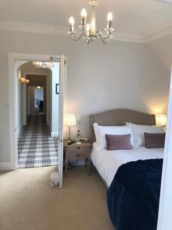 a bedroom with a bed and a chandelier at Ballifeary House in Inverness