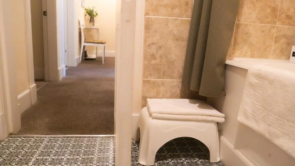 a bathroom with a toilet and a sink and a hallway at Cozy Central Apartment in Inverness