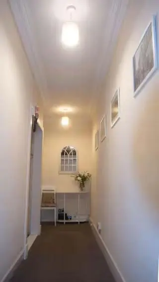 an empty hallway with a white wall and a ceiling at Cozy Central Apartment in Inverness
