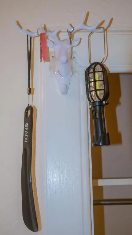 a hockey stick and a flashlight hanging on a wall at Cozy Central Apartment in Inverness
