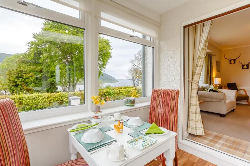 a dining room with a table and a window at Urquhart Bay B&B in Drumnadrochit