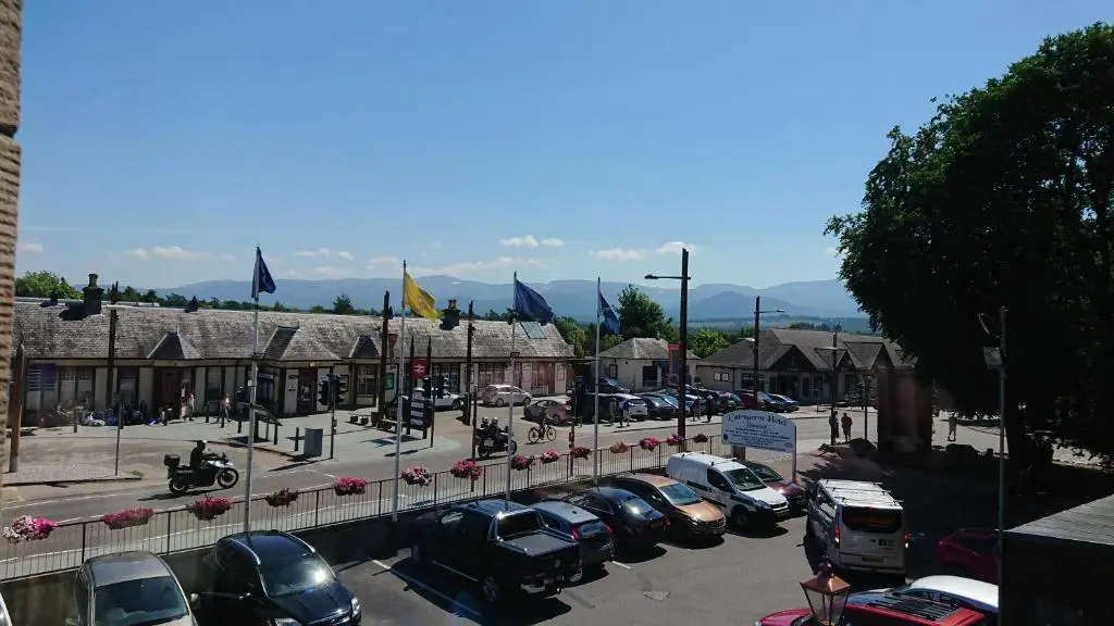 a parking lot with cars parked in front of a building at Cairngorm Hotel in Aviemore