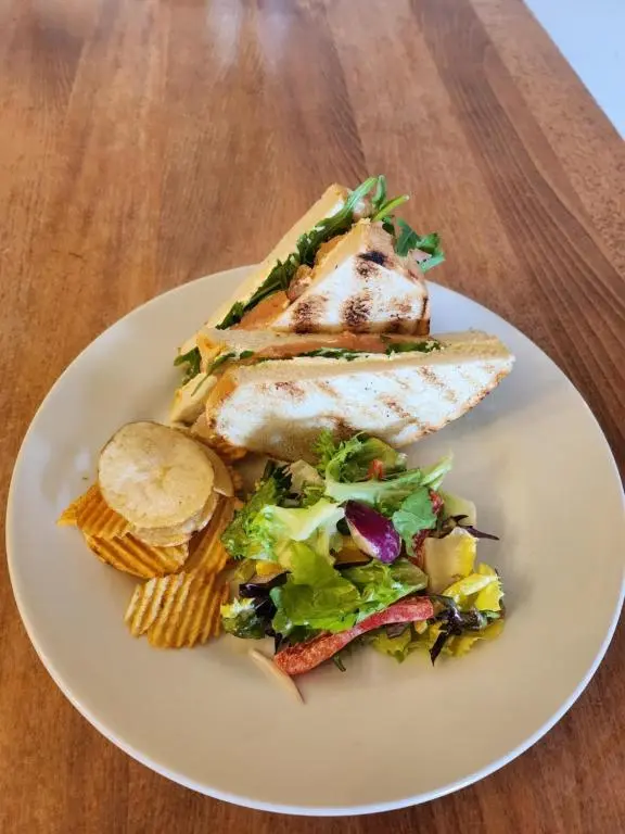 a white plate with fish and a salad on a table at Garth Hotel in Grantown on Spey