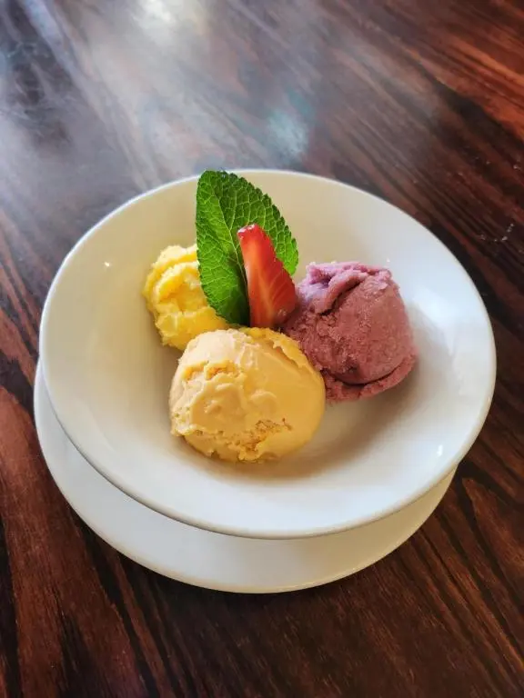 a plate of ice cream with a strawberry on it at Garth Hotel in Grantown on Spey