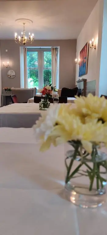 a vase of flowers on a table in a room at Hotel Square in Tomintoul