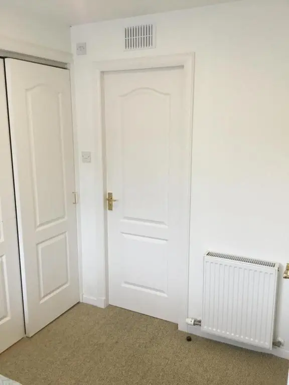 an empty room with a white door and a radiator at Inchmarlo villa27 in Banchory