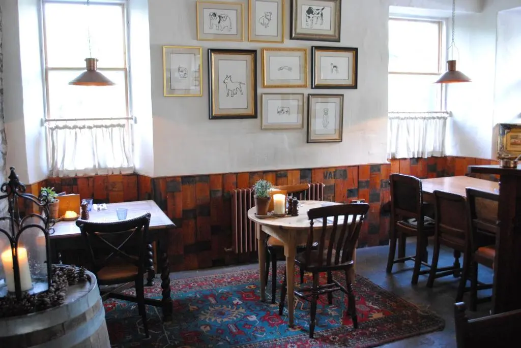 a dining room with tables and chairs and pictures on the wall at Craigellachie Hotel of Speyside in Craigellachie