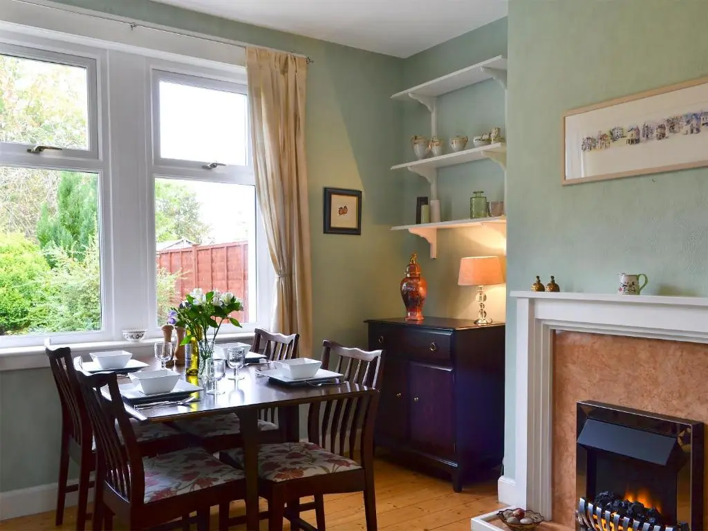 a dining room with a table and a fireplace at Viewhill Villa in Inverness