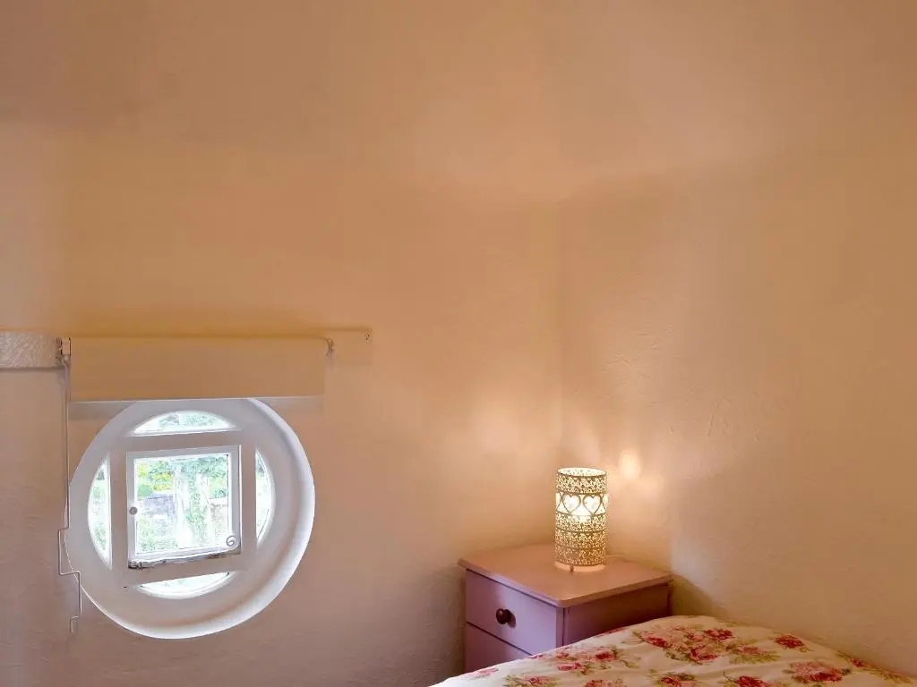 a bedroom with a bed and a round window at Viewhill Villa in Inverness
