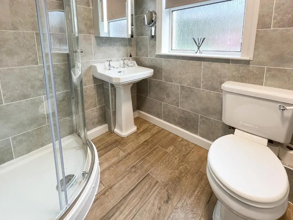 a bathroom with a toilet and a sink and a shower at Riverside Cottage in Drumnadrochit