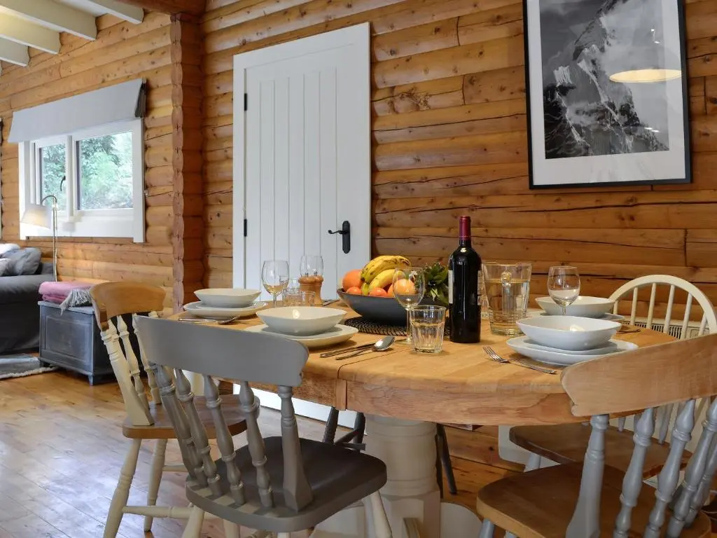 a dining room with a wooden table with a bottle of wine at Glen Hideaway in Balnald