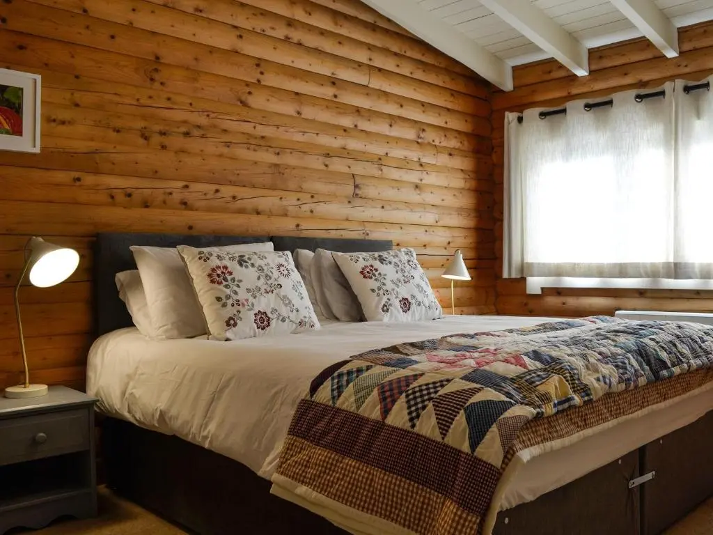 a bedroom with a bed in a wooden wall at Glen Hideaway in Balnald