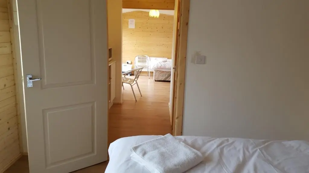 a room with a bed and a dining room with a table at Clunebeg Lodge in Drumnadrochit