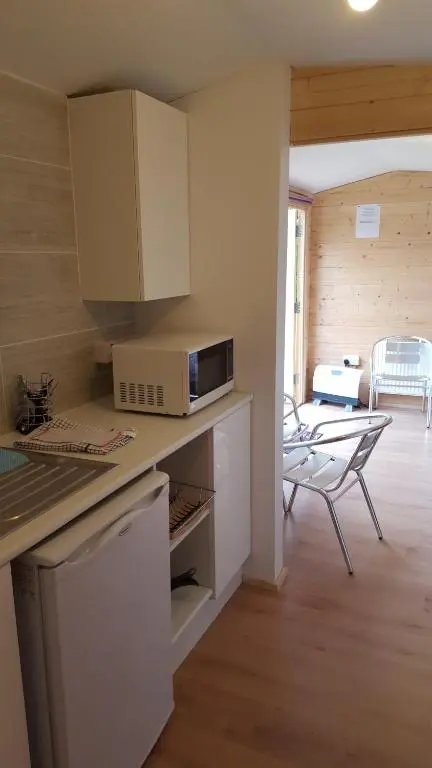 a kitchen with a counter with a microwave and a table at Clunebeg Lodge in Drumnadrochit
