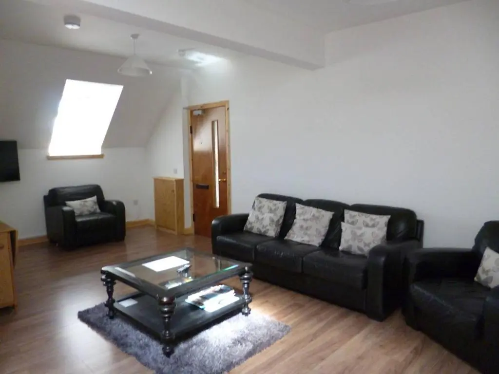 a living room with a black couch and a coffee table at Millburn Apartments in Inverness