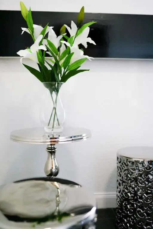 a glass vase with white flowers on a table at Millburn Apartments in Inverness