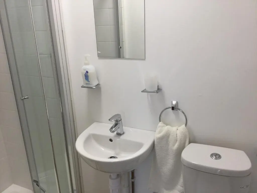 a bathroom with a sink and a toilet and a mirror at 3 Bedroom Culduthel House Free Parking in Inverness