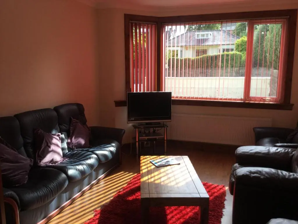a living room with two leather couches and a television at 3 Bedroom Culduthel House Free Parking in Inverness