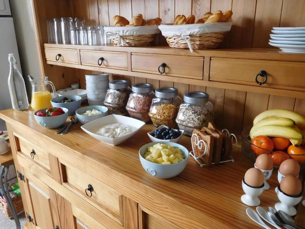 a wooden counter with various bowls of food on it at The Castle B&B in Inverness
