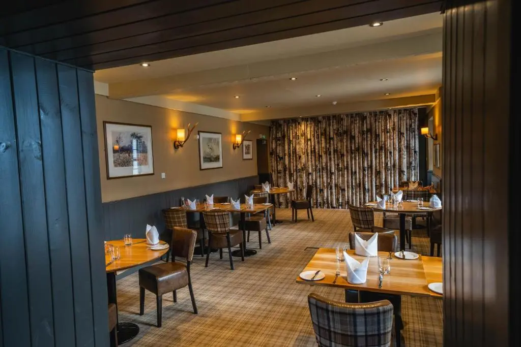 a restaurant with tables and chairs in a room at Maryculter House in Maryculter