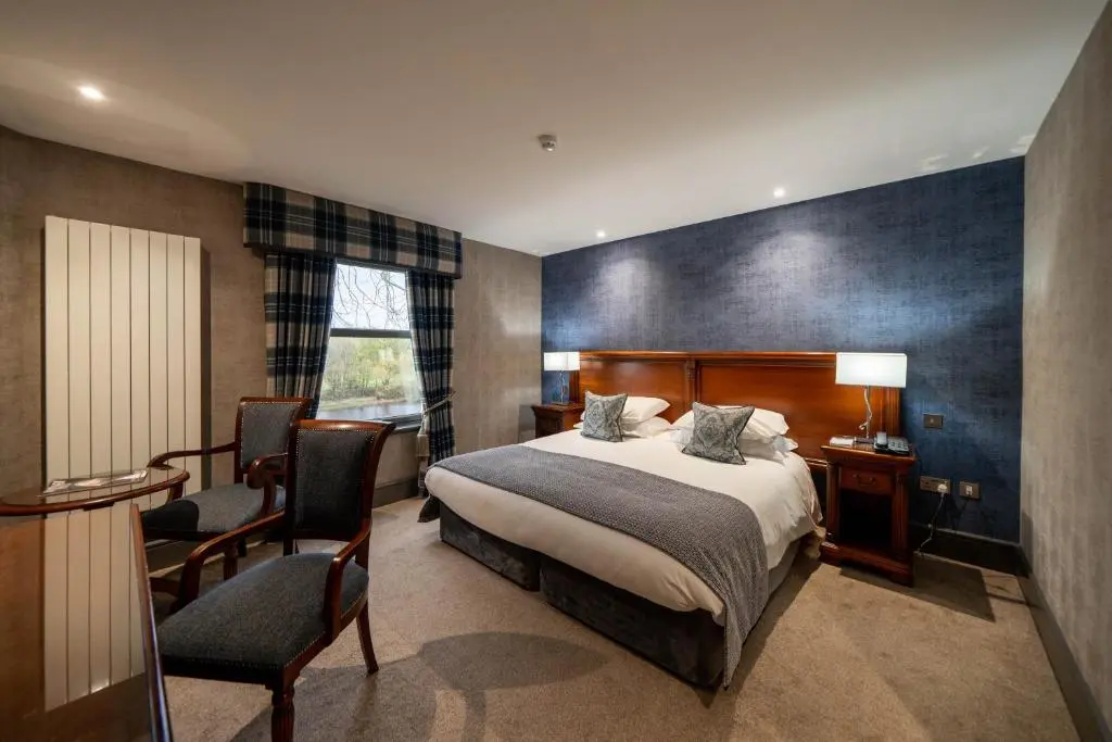 a bedroom with a bed and a desk and a chair at Maryculter House in Maryculter