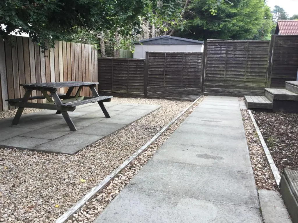 a patio with a picnic table and a fence at Four-Bedroom House - Stratherrick Free Parking in Inverness