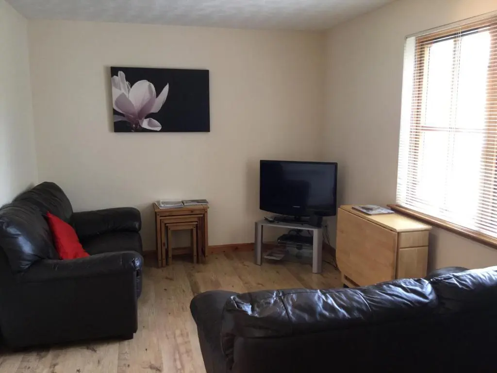 a living room with a couch and a flat screen tv at One-Bedroom Apartment - Wyvis Free Parking in Inverness