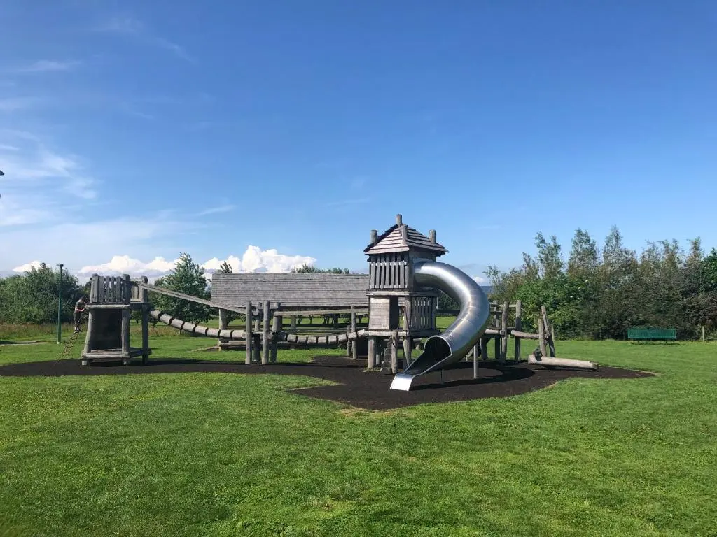 a playground with a slide in the grass at One-Bedroom Apartment - Wyvis Free Parking in Inverness