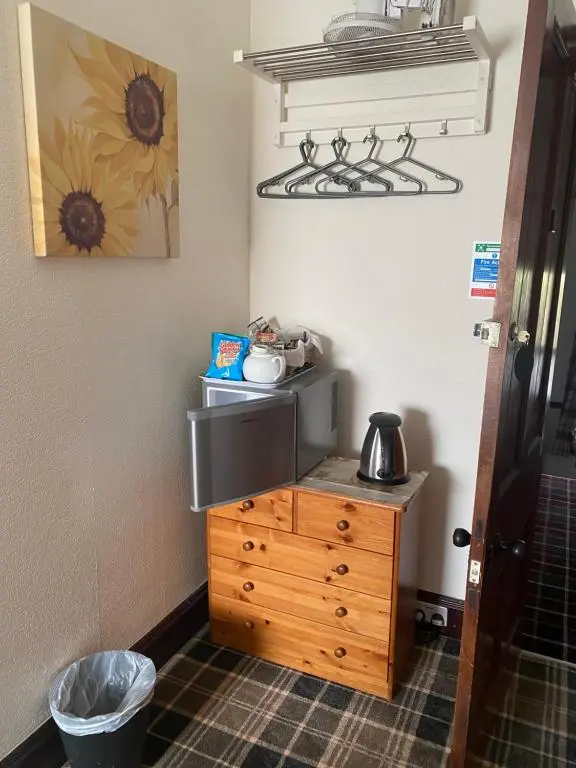 a kitchen with a wooden dresser and a microwave at Cromarty View Guest House Accommodations & B&B in Dingwall