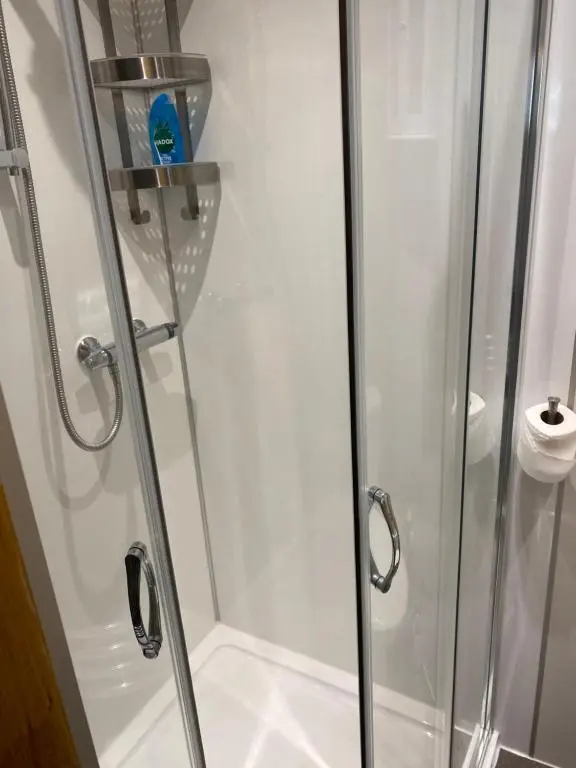 a shower stall with a glass shower door at Cromarty View Guest House Accommodations & B&B in Dingwall