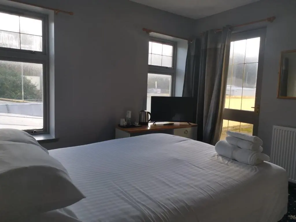 a bedroom with a white bed with towels on it at Marine Hotel in Buckie
