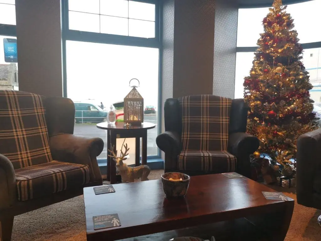 a living room with a christmas tree and a coffee table at Marine Hotel in Buckie