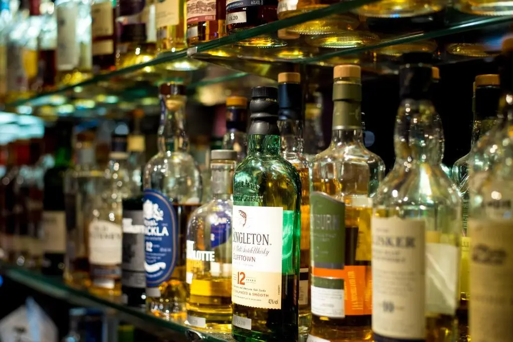 a bunch of bottles of alcohol sitting on a shelf at Laichmoray Hotel in Elgin