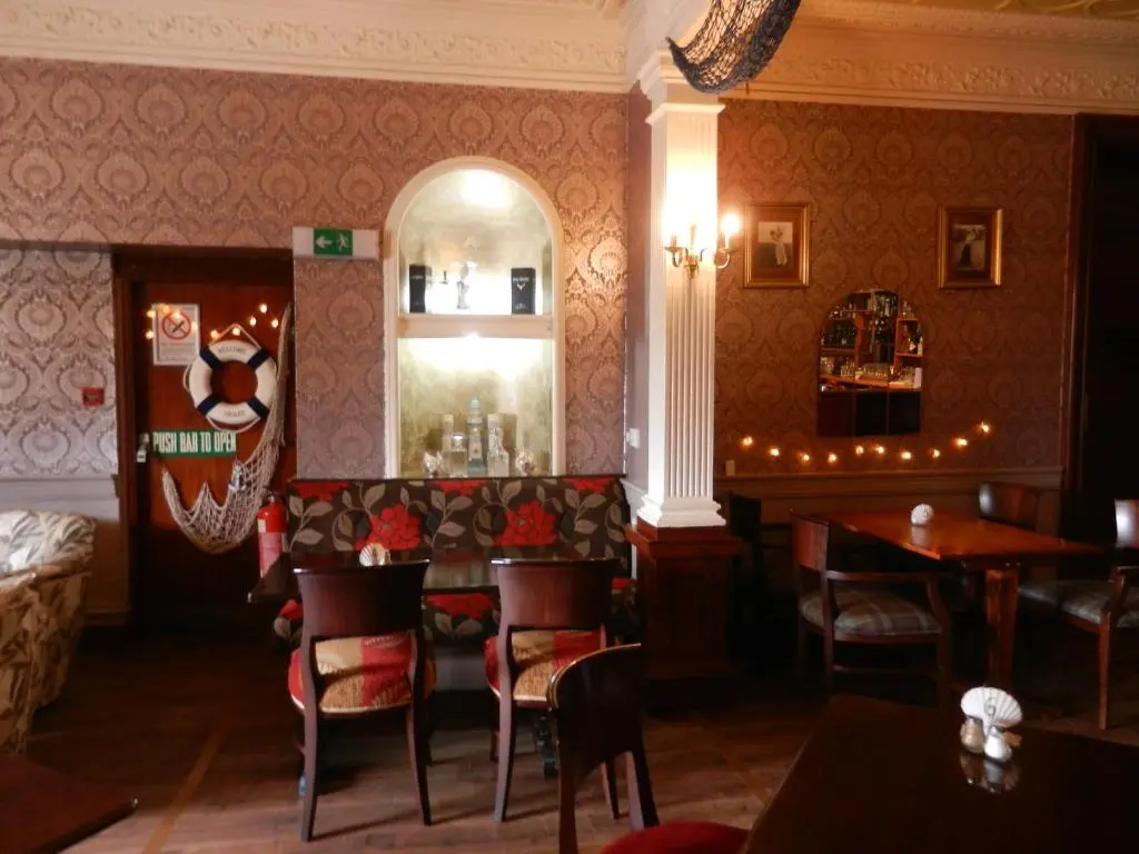 a restaurant with a table and chairs in a room at Mansfield Castle Hotel in Tain