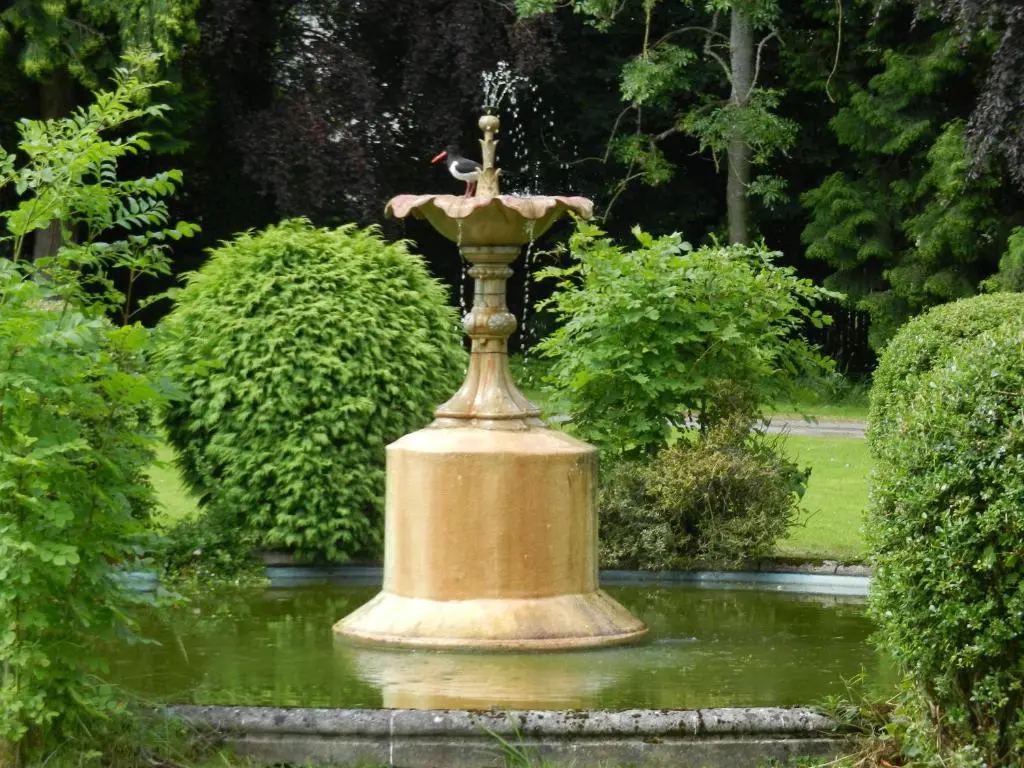 a fountain in the middle of a garden at Mansfield Castle Hotel in Tain