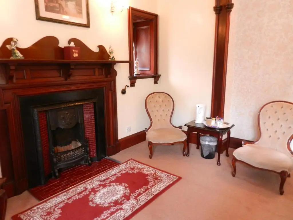 a living room with two chairs and a fireplace at Morangie Hotel Tain in Tain