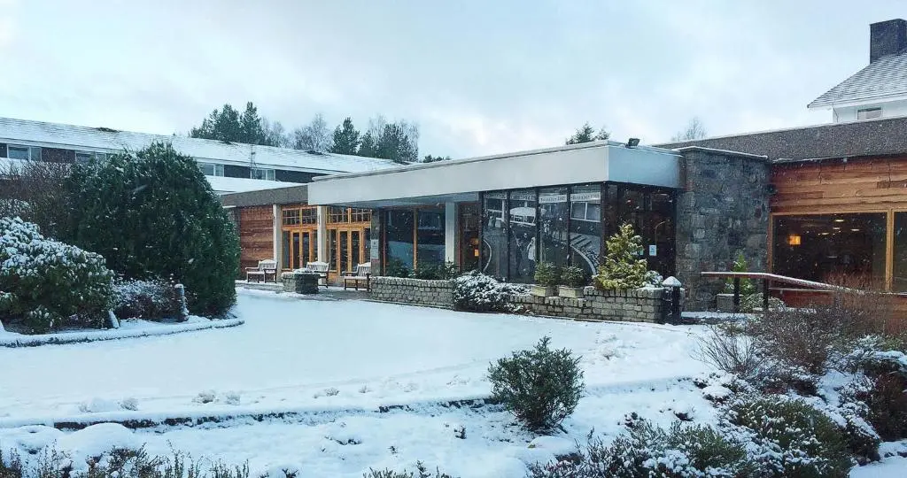 a house with snow on the ground in front of it at Coylumbridge Resort Hotel in Aviemore