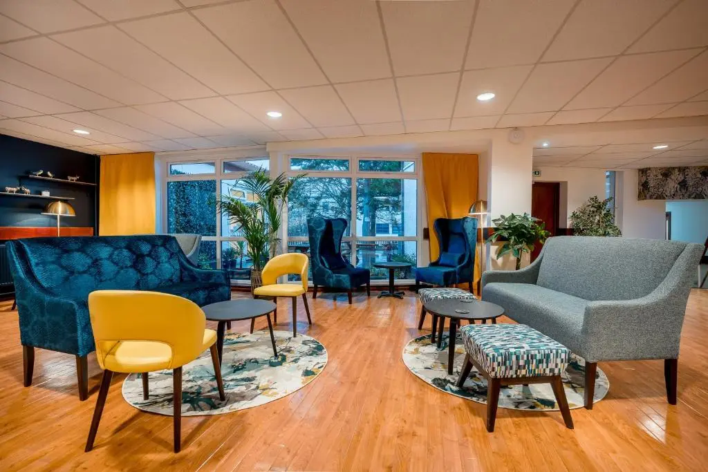 a living room with blue furniture and yellow chairs at Inverness Youth Hostel in Inverness