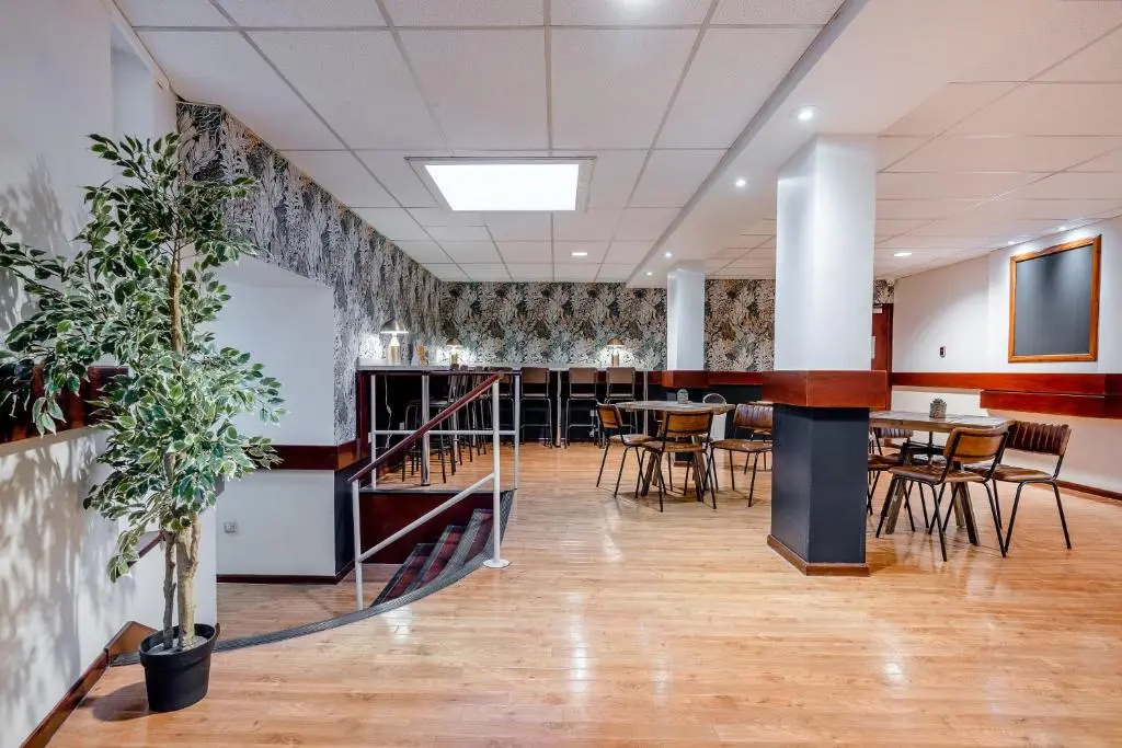 a dining room with tables and chairs and a plant at Inverness Youth Hostel in Inverness