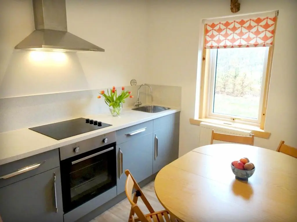 a kitchen with a table and a sink and a window at The \u2018Servants Quarters@Delny House\u2019 in Invergordon